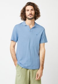 Hellblaues Polohemd mit kurzen Ärmeln, klassischem Kragen und kleinem Logo auf der Brust. Hergestellt aus weichem Stoff mit leicht strukturiertem Finish.