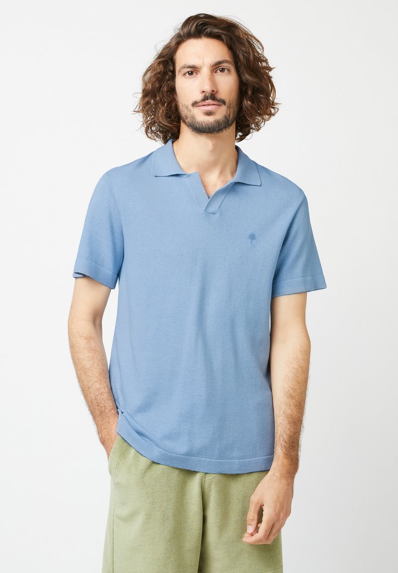 Hellblaues Polohemd mit kurzen Ärmeln, klassischem Kragen und kleinem Logo auf der Brust. Hergestellt aus weichem Stoff mit leicht strukturiertem Finish.