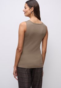 Top senza maniche, con scollo rotondo in taupe, realizzato in un morbido mélange di cotone, caratterizzato da una texture liscia e una silhouette aderente.