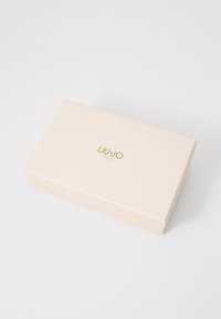 Liu Jo Milano doos in zachtroze met een matte afwerking, voorzien van een gouden logo aan de bovenkant, rechthoekige vorm en een gladde textuur.
