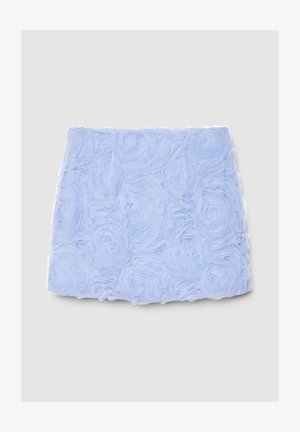 Tissu bleu clair avec un motif floral texturé de pétales enroulés, fini avec une bordure blanche. Design doux et superposé.