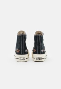 Kotníkové černé plátěné tenisky s barevnými vyšívanými detaily, bílým prošíváním a klasickými gumovými podrážkami se značkou "Converse All Star".