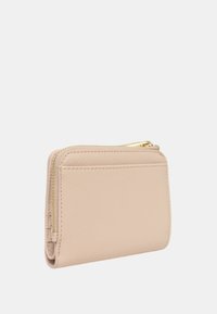 Billetera de color beige con textura y cremallera dorada, que presenta una forma rectangular compacta y un acabado suave, adecuada para tarjetas y objetos pequeños.