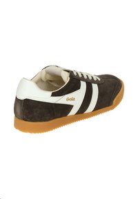 Scarpa sportiva in suede marrone con strisce bianche, design con lacci e suola in gomma naturale con grip testurizzato. Logo Gola in oro sul lato.