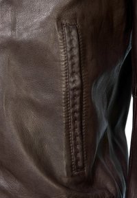 Bruine leren jas met een textuur oppervlak, gedetailleerde stiksels aan de linkerkant en een slank zakontwerp.