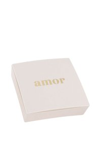 Scatola quadrata bianca con la scritta "amor" in oro sopra. Superficie liscia, leggero luccichio; design minimalista con bordi arrotondati.
