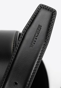 Correa de cuero negro con el logotipo "WITTCHEN" en relieve, costuras precisas y textura suave. El borde de la correa es ligeramente redondeado, lo que proporciona un detalle sutil.