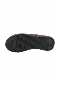 Baskets rouges avec une semelle en caoutchouc noir texturé présentant des motifs ondulés, conçues pour une traction et une durabilité.