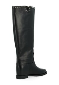 Bottes en cuir noir montantes avec un haut en forme de V, des clous décoratifs le long du bord et une semelle plate. Texture lisse et design minimaliste.