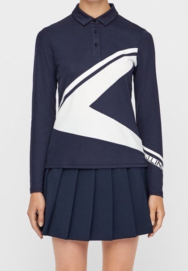 Marinblå pikétröja med lång ärm och vit diagonal randdesign samt klassisk krage, kombinerad med en marinblå plisserad kjol. Tyg av bomullsblandning.