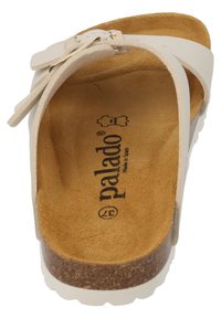 Weiße Zehentrenner mit Korksohle, Wildlederfußbett und verstellbarem Riemen. Besitzt eine glatte Oberfläche und ein minimalistisches Design. Markenname sichtbar.