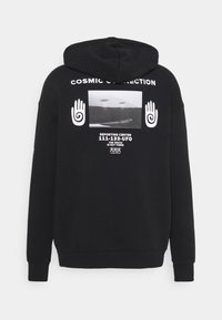 Felpa nera con cappuccio caratterizzata da una grande grafica sul retro, con un'immagine in bianco e nero, testo e disegni a mano, realizzata in tessuto morbido.