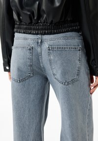 Hellblaue Jeans aus Denim mit entspannter Passform, zwei Gesäßtaschen, dezenten Nähte und einem hohen, elastischen Taillenbund.