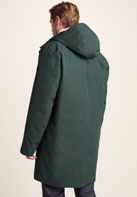 Green, hooded parka with a smooth, matte finish. Features a straight cut and side pockets, designed for warmth and comfort.