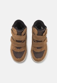 Bruine suede en mesh hoge schoenen met dubbele klittenbandstraps, rubberen zolen en een gladde textuur; van bovenaf weergegeven.