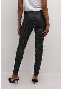 Leggings de piel sintética negra con una cinturilla elástica, diseño ajustado y textura suave, con detalles de costura sutiles.