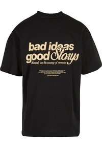 Tricou negru din bumbac cu text mare imprimat în crem: "idei proaste povești bune" și o citare mai mică dedesubt. Mâneci scurte și guler rotund.