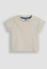 T-shirt pour tout-petit léger beige à manches courtes en coton doux, avec un col rond et deux boutons-pression à l'épaule.