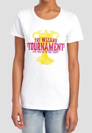 Person wearing a white T-shirt with a yellow trophy and red text "Tri Wizard Tournament Are You Up To The Task?"