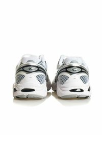 Coppia di scarpe da corsa atletiche bianche e argento viste da dietro su una superficie bianca riflettente.