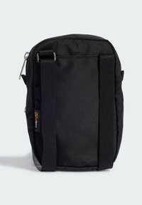 Svart tygaxelväska med strukturerad form, justerbara remmar och dragkedjestängning. Har en liten logotagg på sidan.