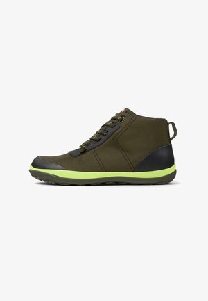 Zapatillas altas de color verde oliva con detalles en negro, tejido texturizado, cordones redondos y suela verde lima. Presenta un talón negro y una lengüeta para facilitar el calzado.
