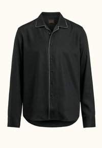 Maglietta nera a maniche lunghe realizzata in tessuto morbido, con colletto a camicia, chiusura frontale con bottoni e piping bianco a contrasto lungo il colletto e il davanti.