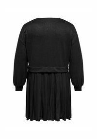 Abito nero con lunghe maniche a sbuffo e vita stretta che si trasforma in una gonna fluida. Realizzato in tessuto testurizzato.
