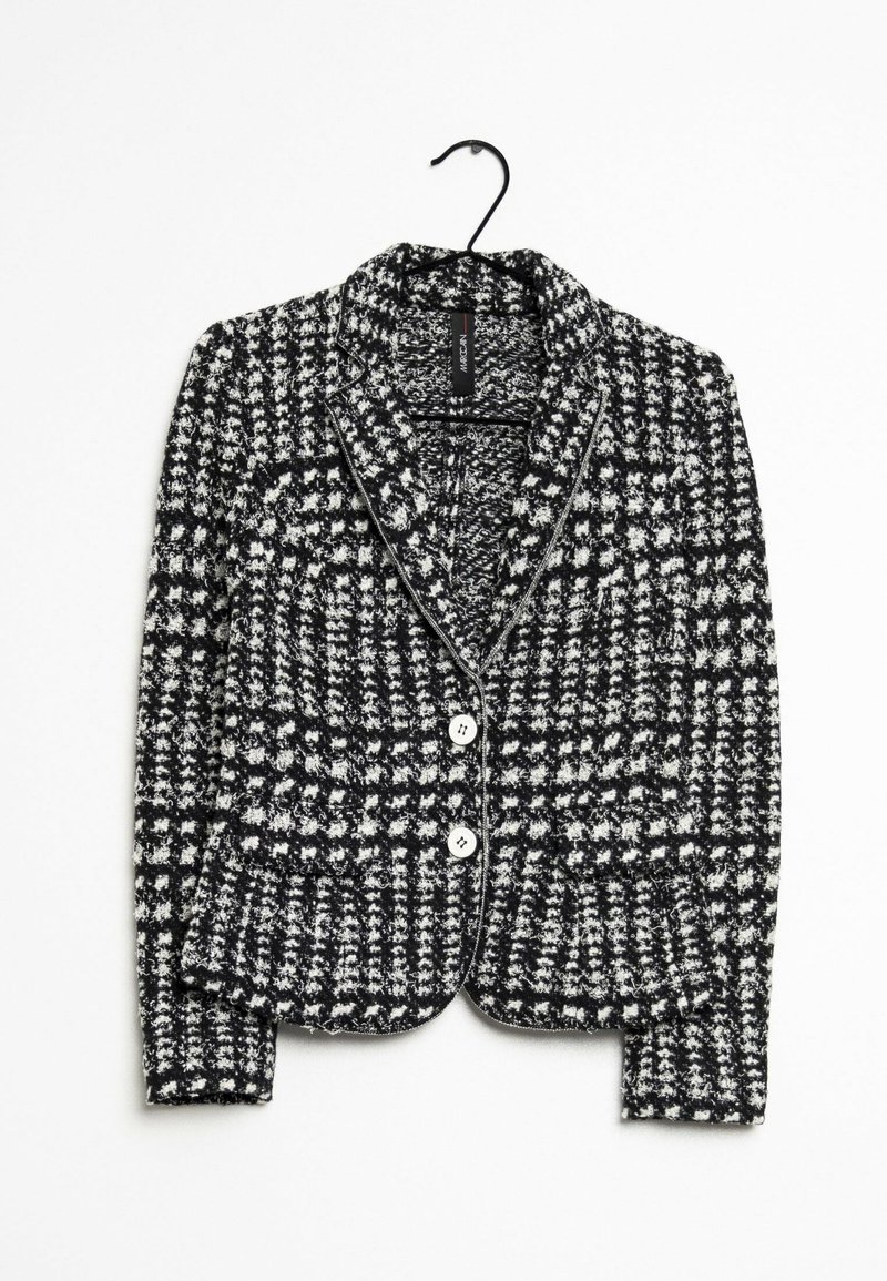 Blazer à motifs noir et blanc avec un tissu texturé, col cranté, boutons sur le devant et ourlet droit, suspendu à un crochet.