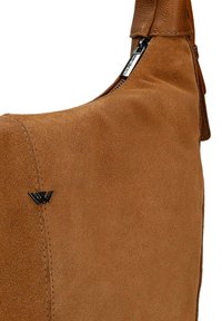 Brązowa torebka zamszowa z zamkiem błyskawicznym na górze oraz małym czarnym metalowym logo z przodu.