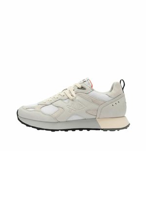 Sneaker sportivo bianco e grigio chiaro con pannelli in mesh e pelle, chiusura frontale con lacci, suola in gomma nera e logo geometrico sul lato.