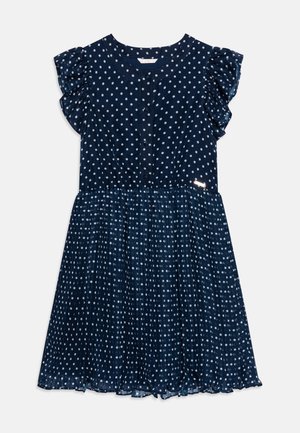 Robe bleu marine à pois blancs, avec manches courtes à volants, boutonnée devant et jupe plissée avec un léger éclat.