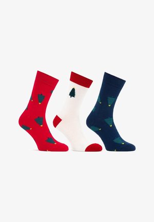 Zestaw trzech skarpetek do kostek: czerwone z zielonymi drzewami, kremowe z pojedynczym zielonym drzewem oraz granatowe z rozsianymi zielonymi drzewami i żółtymi gwiazdami.