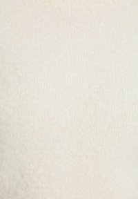 Maglione a maglia color crema con texture a costine. Presenta un collo rotondo e un tessuto morbido, adatto per un abbigliamento casual.