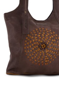 Brown leather tote bag with a circular woven pattern in lighter brown. Features a textured finish and a brand tag attached.
