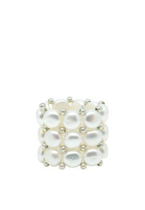 Large bague composée de trois rangées de perles blanches reliées par de petites perles argentées sur un fond blanc.