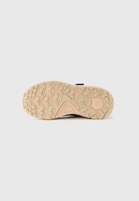 Suola di scarpa in gomma beige con un motivo di battistrada geometrico testurizzato e logo circolare, esposta su uno sfondo bianco.