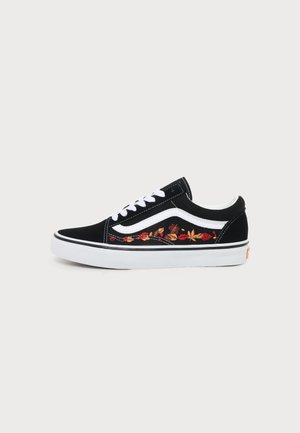 Basket basse noire avec des lacets et une semelle blancs, une bande blanche sur le côté et des fleurs rouges et orange brodées.