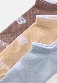 Três pares de meias até ao tornozelo em castanho, bege e azul claro. Cada uma apresenta um design texturizado e um logotipo branco na lateral.