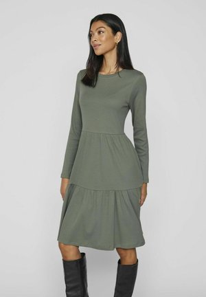 Robe à manches longues, verte olive, en tissu côtelé, avec une jupe à volants et un col rond, offrant une coupe décontractée.