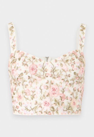 Λευκό κοντό τοπ με ροζ και πράσινη λουλουδένια κεντητική και λεπτές τιράντες, με μικρό κεντρικό φερμουάρ στο ντεκολτέ.