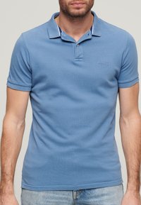 Polo shirt azzurro chiaro in cotone, con colletto a tre bottoni, maniche corte e logo ricamato sul petto.