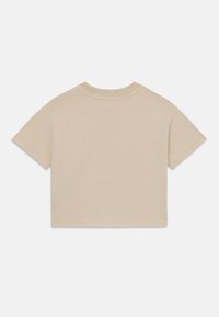 Beige cropped t-shirt lavet af blød bomuld, med korte ærmer, rund halsudskæring og pæne syninger langs kanterne.