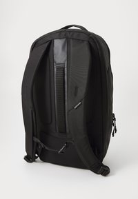 Svart ryggsekk med polstrede stropper og rygg, laget av slitesterk stoff, med justerbare spenner og et slankt, ergonomisk design.