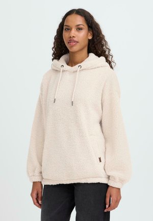 Krämfärgad hoodie gjord av mjukt, fluffigt material. Har en stor huva, dragsko och elastiska ärmslut. Sidologga synlig.