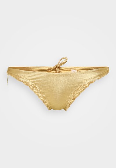 Parte de baixo de biquíni dourada com um acabamento brilhante, apresentando bordas frufru, um fecho lateral com laço e uma textura de tecido delicada.