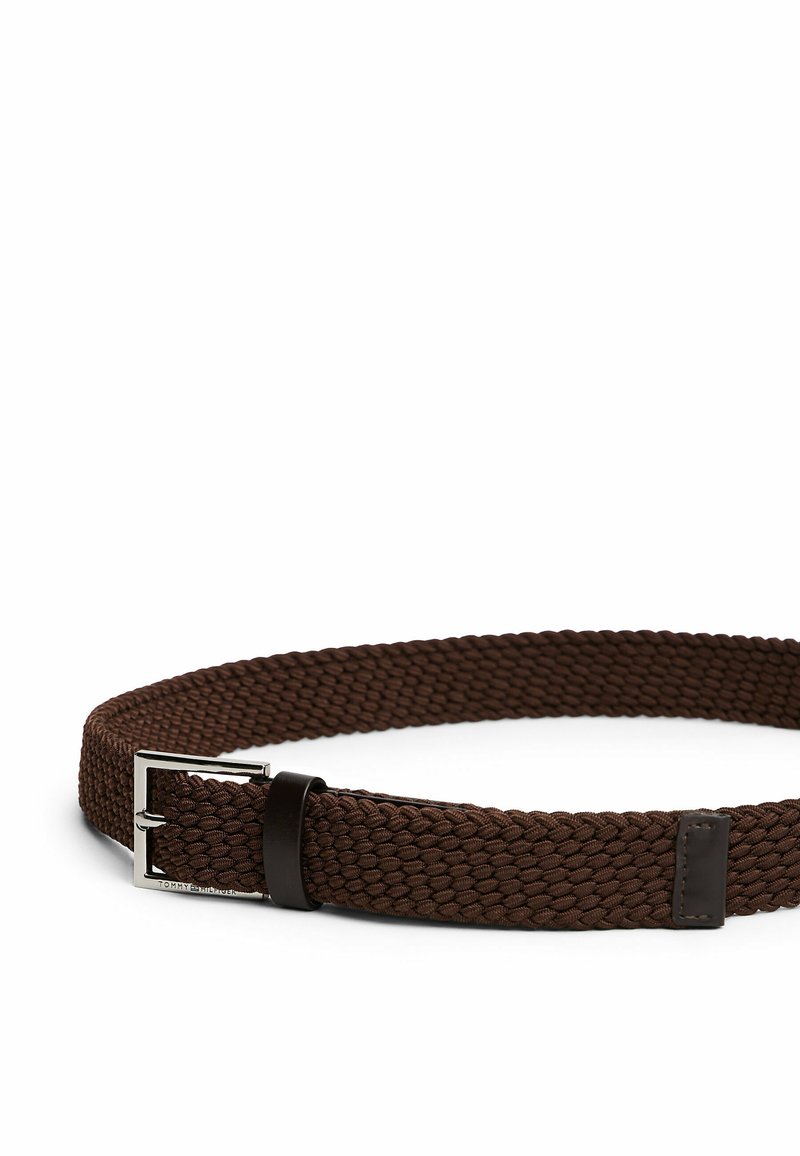 Ceinture élastique tissée marron avec une boucle en métal argenté et des accents en cuir marron foncé. Texture lisse avec un design flexible.