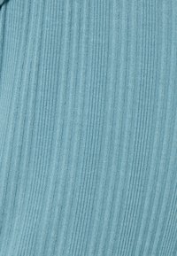 Tejido de un azul claro con textura de rayas verticales, que presenta finas líneas en relieve, suave al tacto y con un acabado liso.