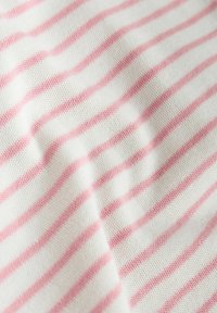 Tessuto di cotone leggero con sfondo bianco e strisce rosa sottili alternate, caratterizzato da una superficie morbida e texture.
