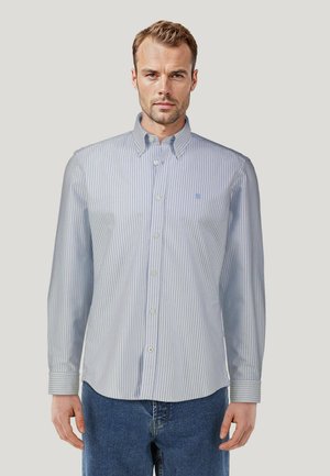 Chemise rayée bleu clair et blanche avec un col à boutons, des manches longues et un petit logo brodé sur la poitrine. Tissu en coton.
